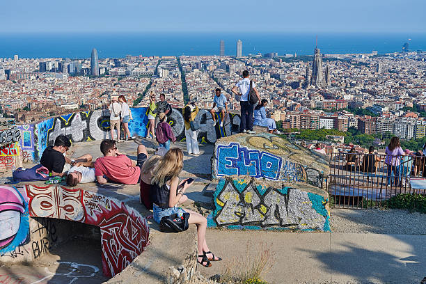 Barcelona, Spain - June 09, 2025: tourists and local people enjoy a sunny afternoon overlooking Barcelona cityscape from the terrace of Bunkers del Carmel, a hill-side location in Horta-Guinardo district.