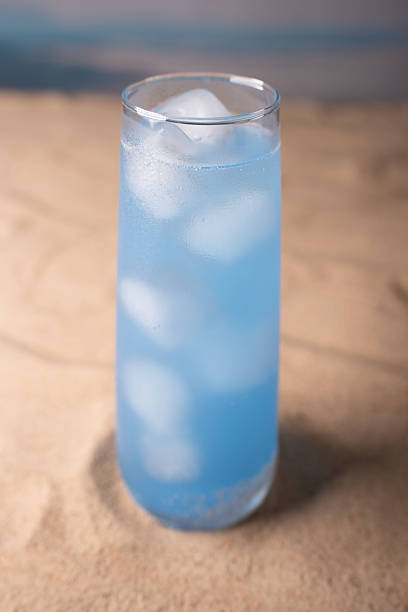 istock refreshing blue beverage in tall glass with ice cubes on sandy beach background evokes coastal vibes and summer time relaxation by the ocean, refreshing, carefree, serenity, fluid, splash, paradise 2236333283