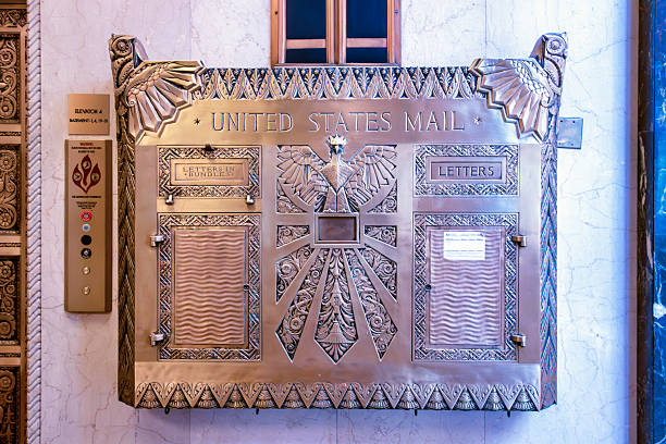 Baltimore MD USA May 12 2018: A chute-fed, brass, Art Deco mailbox is still in use in the lobby of an early multi-story office building in Baltimore, Maryland.