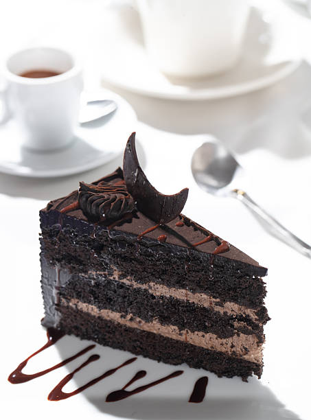 A slice of chocolate cake served with coffee and espresso