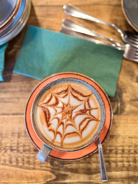Image of drinking halloween hot chocolate with cocoa and spider web art, featuring milky spooky drink, festive autumn beverage