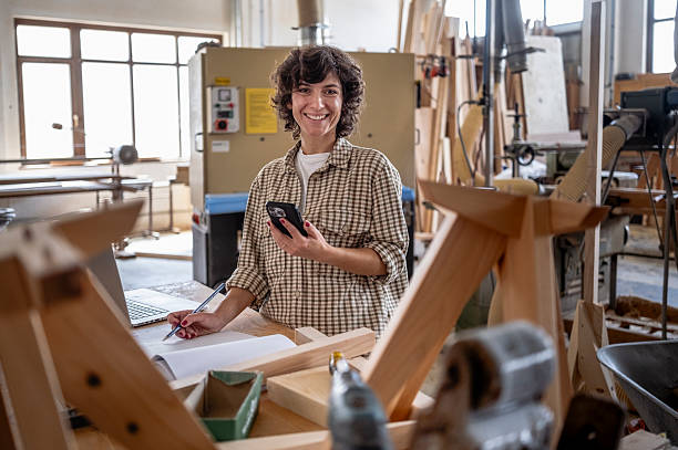istock Focused Female Carpenter Managing Workshop with Bright Natural Lighting and Organized Layout 2236339799