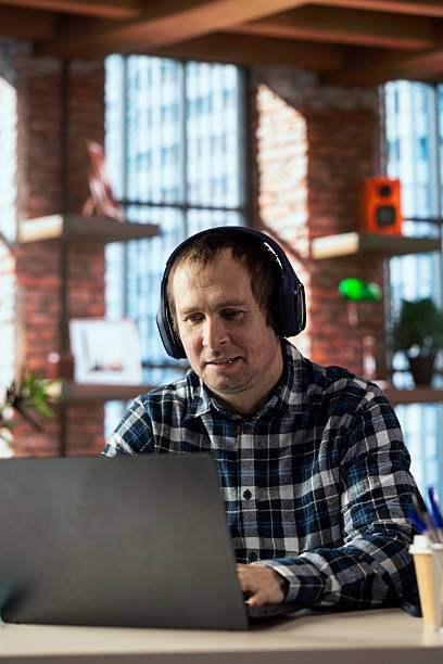 istock Worker at desk participating in online training session on laptop in home office 2236342669