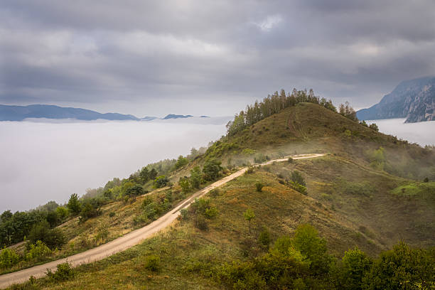 Country road on the hill above the fog.