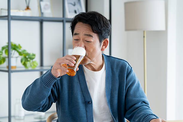 istock Middle-aged man drinking beer at home 2236351575