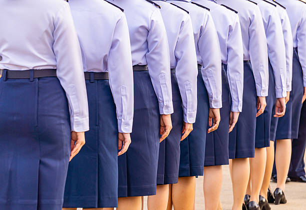 Female soldiers in white uniforms stand in line.