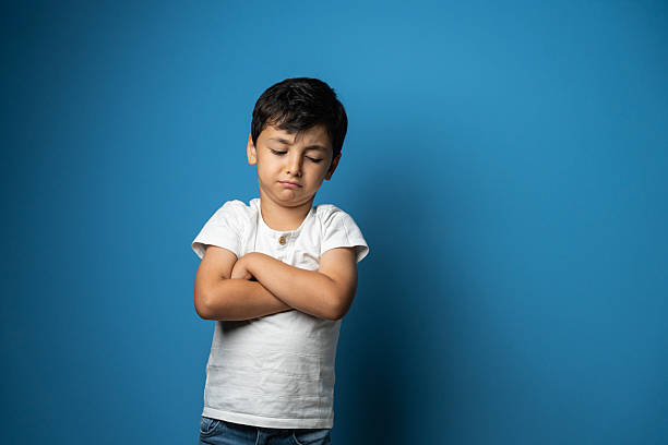 Cute little boy making a sad face, studio shot
