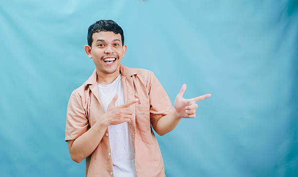 istock A Joyful Young Man Posing Against a Light Blue Background with a Brightly Expressive Gesture 2236360948