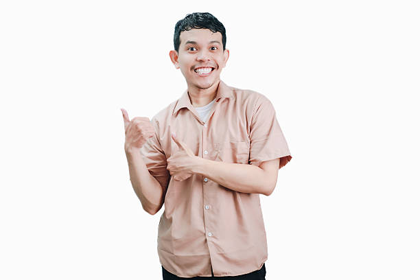 istock Smiling Young Man Pointing to the Side with Both Thumbs Up. 2236361302