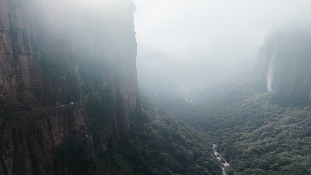Traveler on cliff hiking with backpack Travel Lifestyle concept adventure active vacations outdoor rocky mountains Landscape aerial view on background