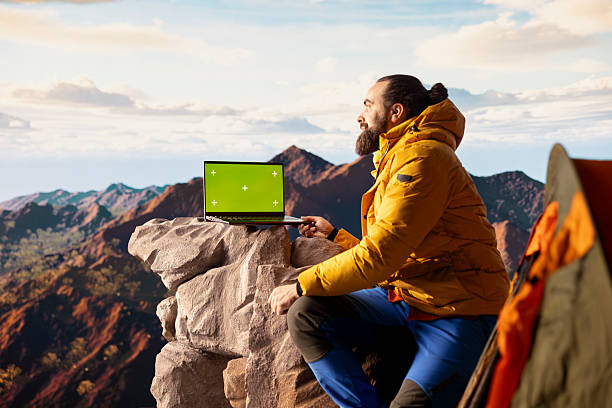 istock Mountaineer stands at the peak with satisfaction and uses mockup screen 2236367205
