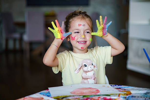 istock Happy child showing colorful painted hands and messy face. 2236370810