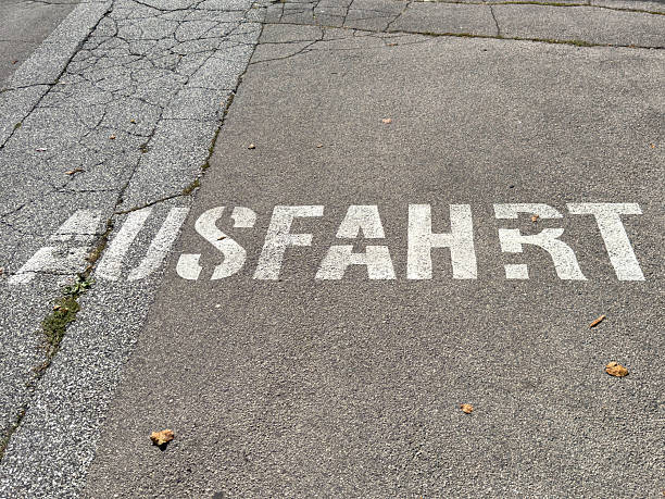 istock Weathered asphalt with german 'ausfahrt' signage on pavement 2236371627