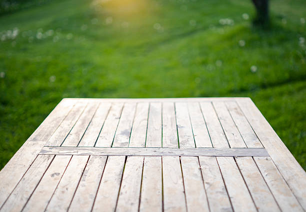 istock Empty rustic wooden table outdoors with nature background and soft golden sunlight 2236377750