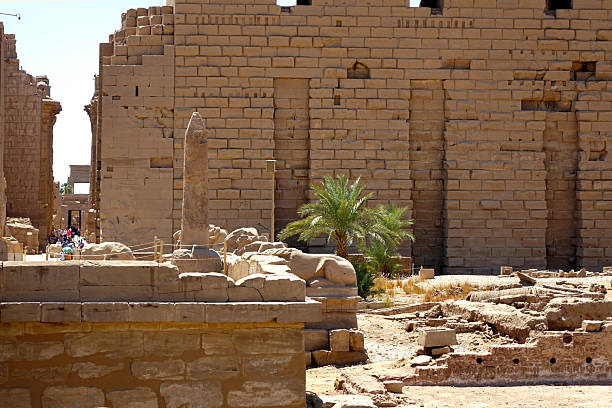 Visitors explore the majestic Karnak temple complex in Egypt, where towering obelisks and ancient stone walls stand testament to a rich historical legacy spanning centuries.