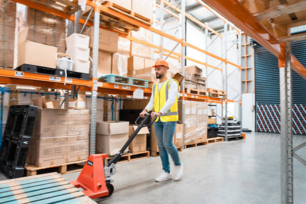 istock Factory staff pushing an empty transport cart in warehouse. 2236378546