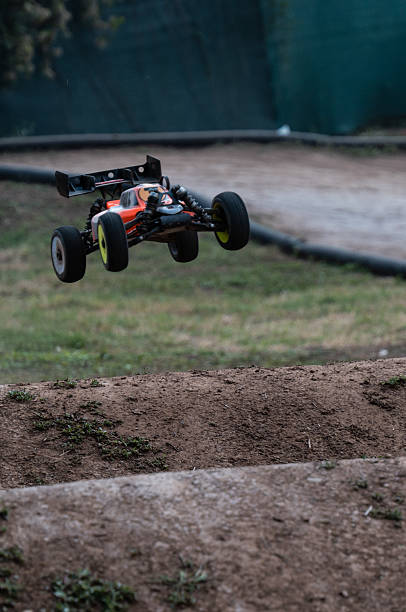 Radio-controlled car jumping on dirt track