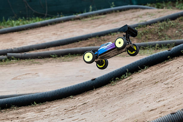 Radio-controlled car performing a jump on a dirt track