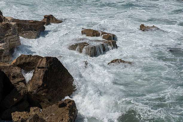 A scenic coastal landscape, featuring a dramatic cliff face overlooking the vast expanse of the ocean under a clear, blue sky