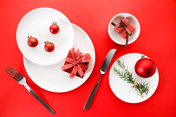 istock White dishes with Christmas ornaments on red background. 2236387842