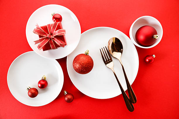 istock White dishes with Christmas ornaments on red background. 2236387846