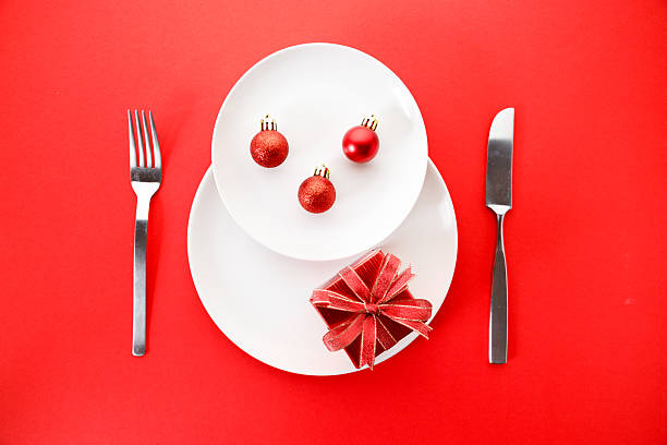 istock White dishes with Christmas ornaments on red background. 2236387847