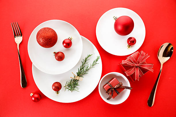 istock White dishes with Christmas ornaments on red background. 2236387849