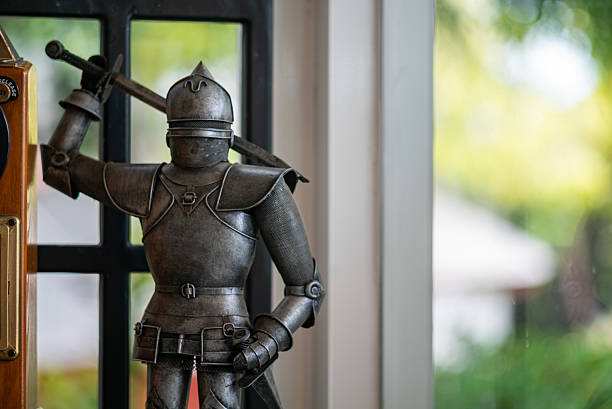 A vintage metal knight sculpture stands elegantly by a window, adding charm and character to any interior space. Perfect for art lovers and collectors.