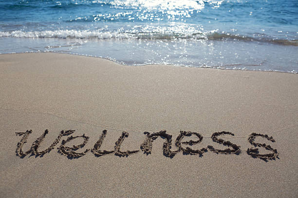 istock Word wellness handwritten on the caribbean sand. 2236393354