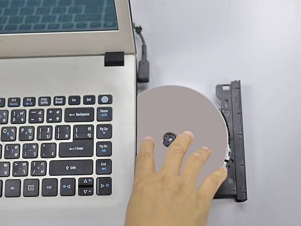 istock The image shows a hand placing or removing a DVD or CD from the drive. 2236394911