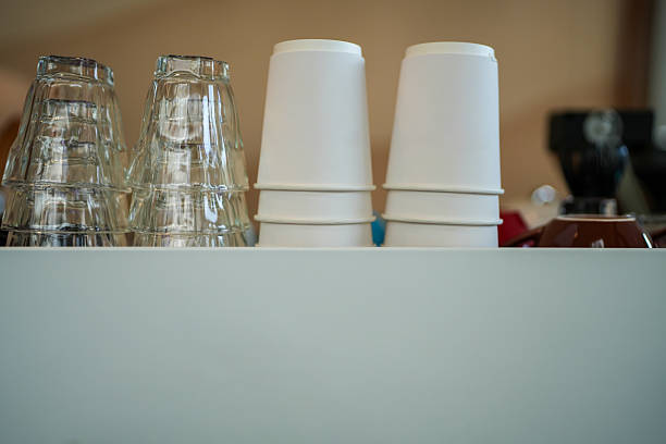 An overhead flat lay captures a grid of unbranded plastic bubble tea cups with aligned circular rims creating rhythmic repetition. Natural light diffuses through translucent cup walls, casting soft halos while matte surfaces contrast with rim highlights. Pre-punched straw holes emphasize functional design, suitable for beverage branding, packaging mockups, FMCG e-commerce visuals, or abstract minimalism projects.