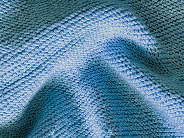 istock Light blue knitted textile with folds, macro background. 2236405894