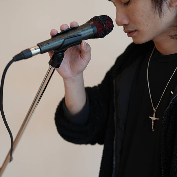istock Young artist passionately performing on stage with microphone in hand, showcasing dedication to music and emotional connection with audience 2236405965