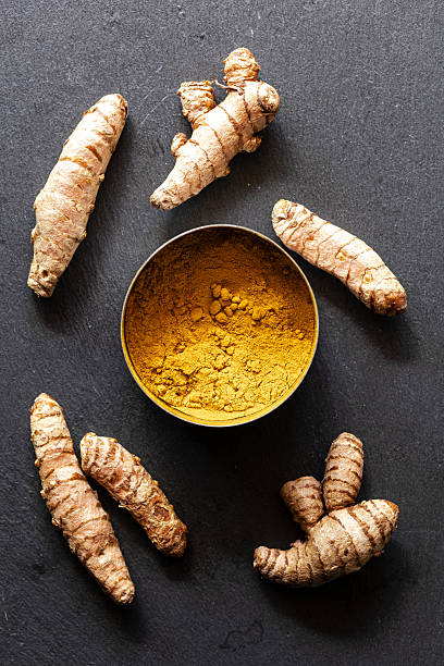 istock Fresh Turmeric Roots and Ground Powder on Dark Slate Background 2236407185