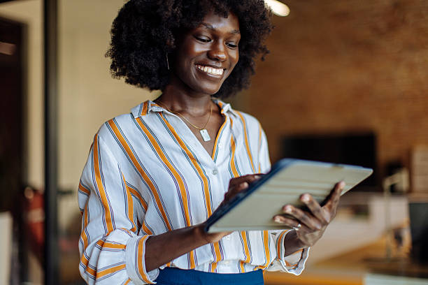 istock Smiling Professional Woman Using a Digital Tablet in a Modern Office Setting 2236408236