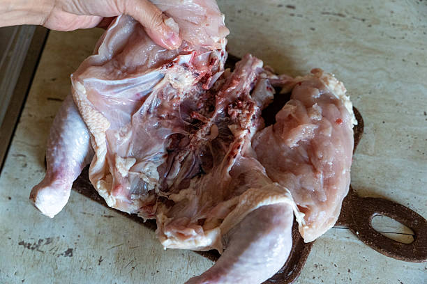 istock Chef preparing raw chicken for cooking on cutting board 2236412992