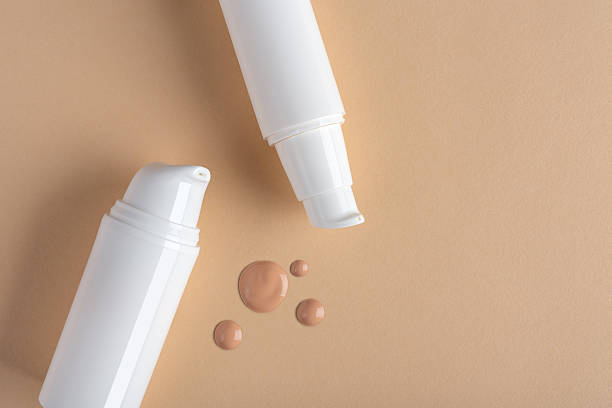 istock Minimalistic cosmetic composition with white tubes and drops of foundation 2236414187