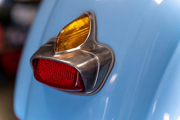Red taillight and orange indicator light shining on a restored vintage light blue scooter