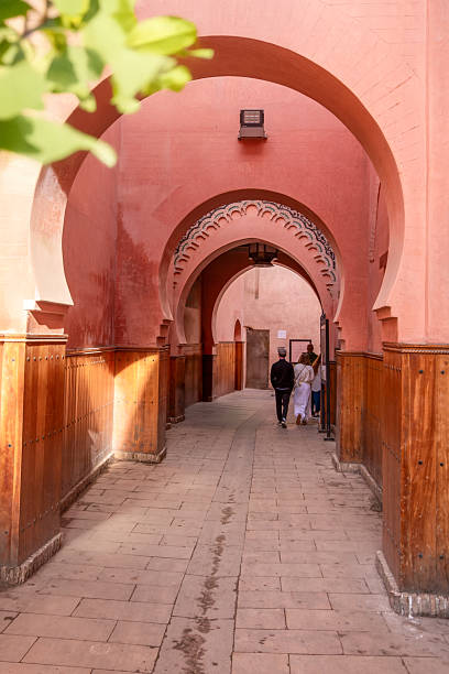 A passageway by the Ben Youssef Madrasa in Marrakesh, featuring traditional red arches and wooden panels that reflect the city’s architectural heritage.