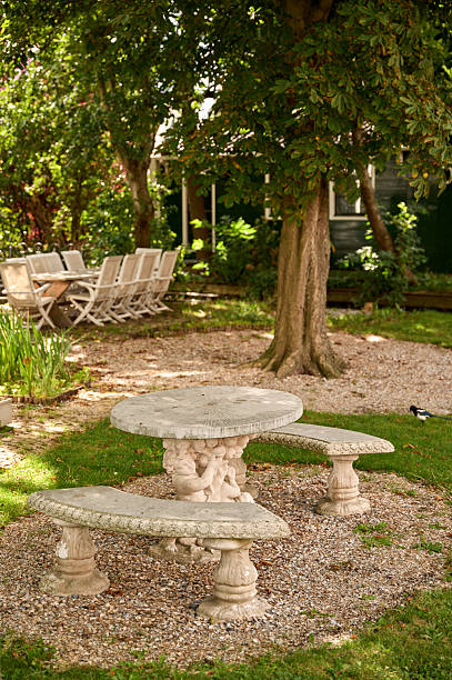 istock Stone table and benches in peaceful backyard garden 2236425325
