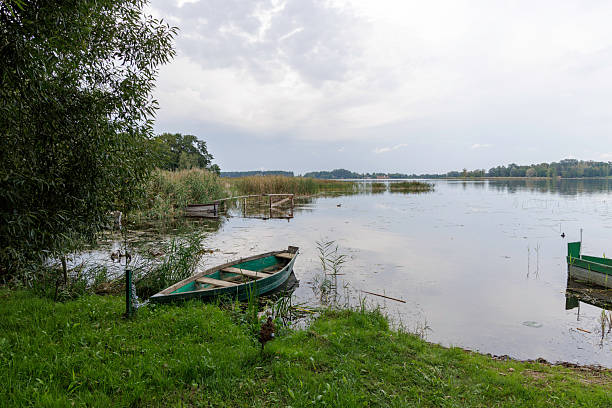 istock A tranquil lake with a green wooden boat. 2236428038
