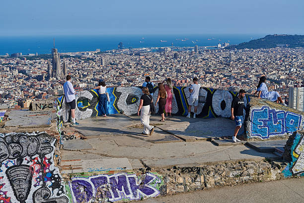 Barcelona, Spain - June 09, 2025: tourists and local people enjoy a sunny afternoon overlooking Barcelona cityscape from the terrace of Bunkers del Carmel, a hill-side location in Horta-Guinardo district.