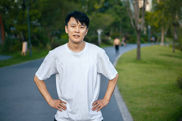 A young Asian man is preparing to exercise in the park