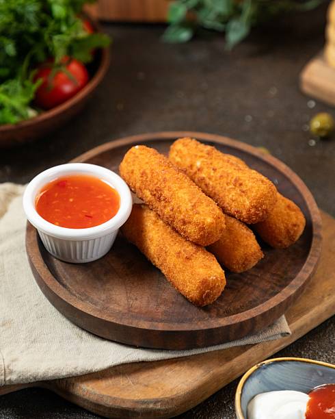 istock Crispy breaded sticks served with tangy sauce and fresh ingredients in a cozy kitchen setting 2236435665
