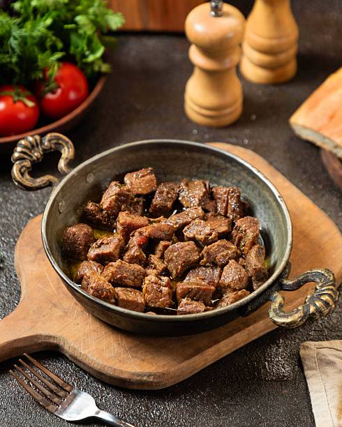 istock Deliciously cooked beef chunks served in a rustic bowl on a wooden board with fresh vegetables for a hearty meal 2236435720
