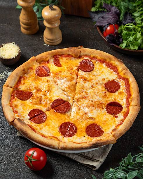istock Freshly baked pepperoni pizza served with vibrant accompaniments on a rustic table 2236437038