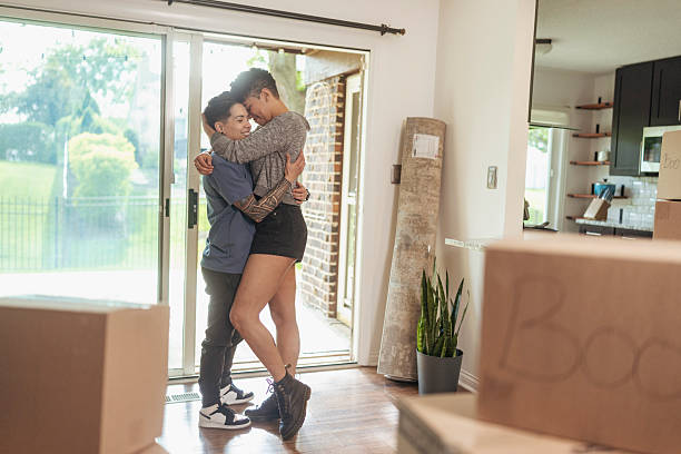 istock Lesbian Couple Embracing in New Home with Moving Boxes 2236437099
