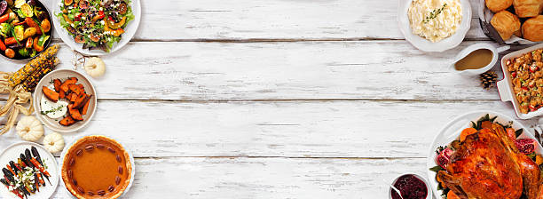 istock Thanksgiving turkey dinner. Top down view double border on a rustic white wood table banner background. 2236438112