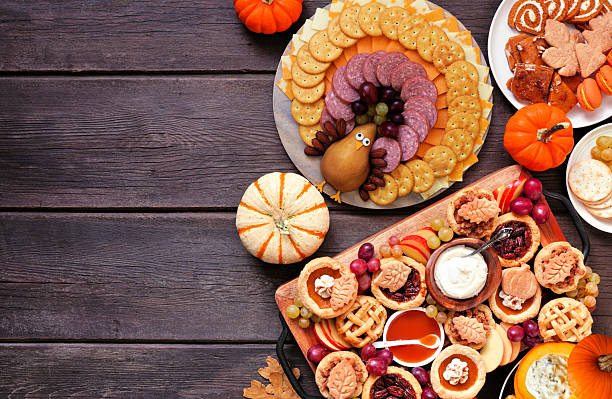 istock Thanksgiving appetizers, sweets and grazing boards. Top down view side border on a dark wood background. 2236438113