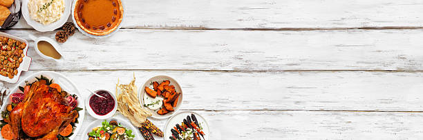 istock Thanksgiving turkey dinner. Top down view corner border on a rustic white wood table banner background. 2236438115
